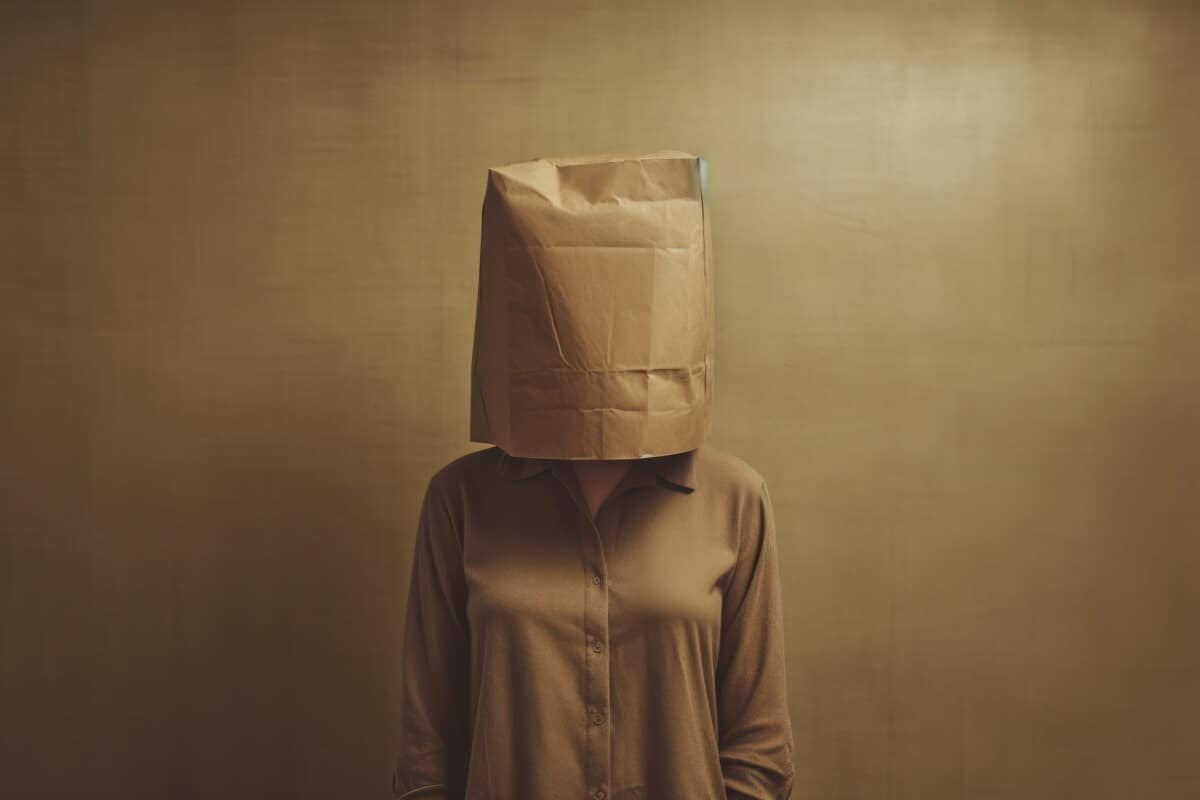 Introverted woman wearing brown paper bag over her head