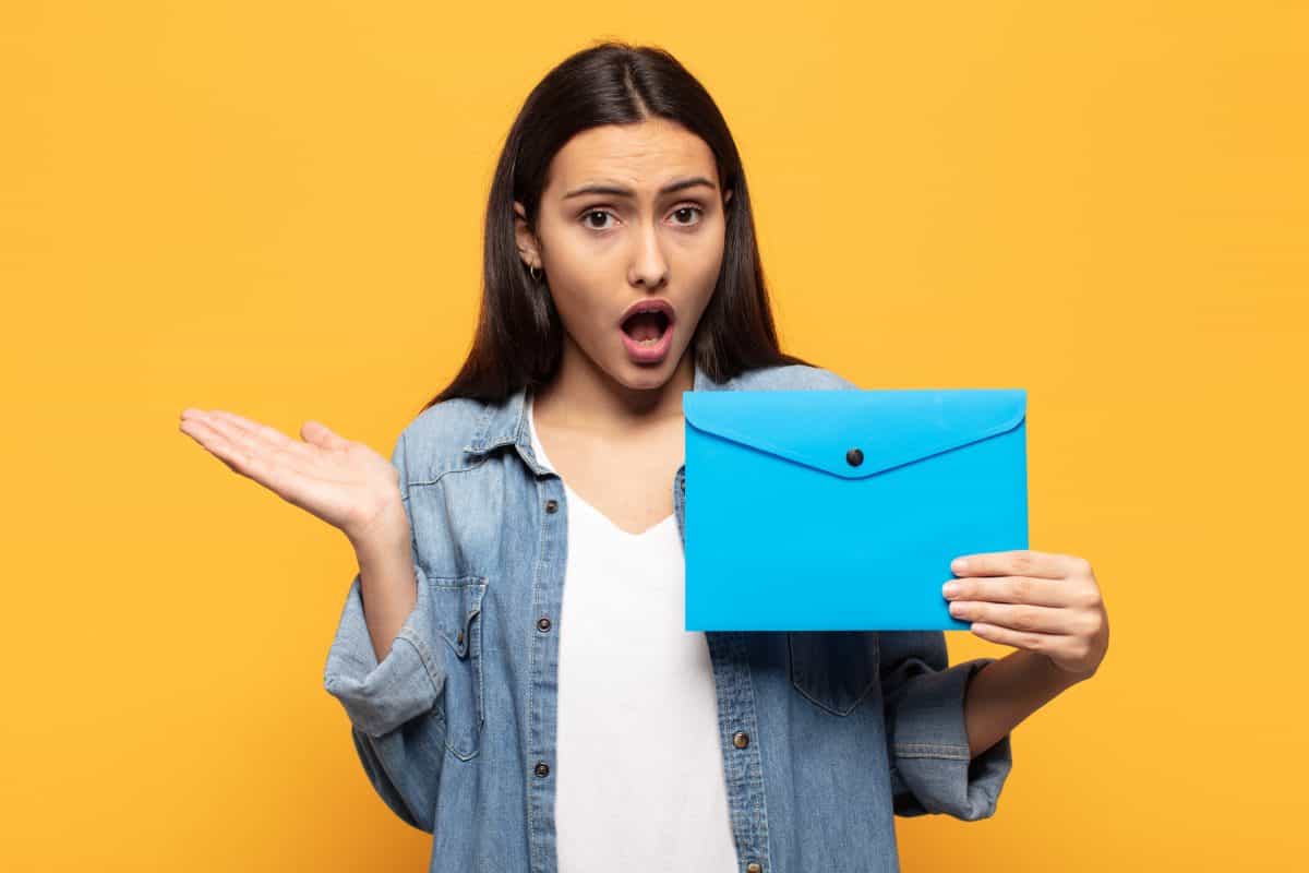 Surprised woman holding envelope
